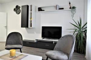 a living room with two chairs and a television at Tiziano T1 in Zagreb