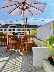 een tafel en stoelen en een parasol op een patio bij ElBanna FAmily Home syariah 5BR in Malang