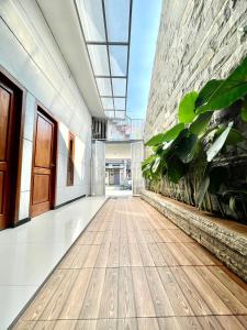un couloir vide avec des plantes dans un bâtiment dans l'établissement ElBanna FAmily Home syariah 5BR, à Malang
