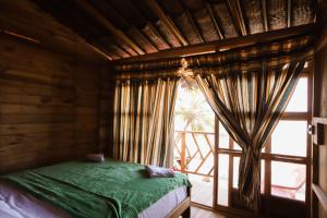 a bedroom with a bed and a large window at Puerto Manglar Hostel in Guachaca