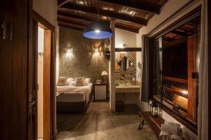 a bedroom with a bed and a television in a room at Pousada Alecrim do Campo in Sao Jorge