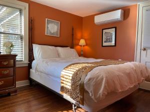 a bedroom with a large bed with orange walls at DeBary Inn in Summit