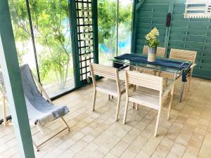 un tavolo da pranzo e sedie sul portico di Mandala Mielno Camping a Mielno