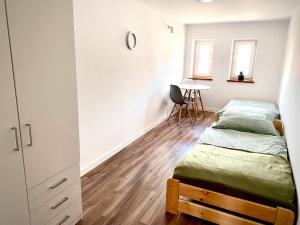 a bedroom with two beds and a table at Noclegi przy Gołębiarce in Wleń