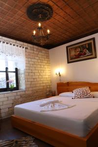 een slaapkamer met een groot bed en een bakstenen muur bij Vila Darla in Berat