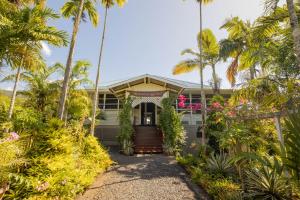 una casa con palmeras delante en The Samoan Outrigger Hotel, en Apia