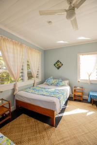 ein Schlafzimmer mit einem Bett und zwei Fenstern in der Unterkunft The Samoan Outrigger Hotel in Apia