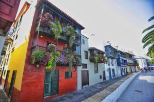 un edificio colorido con cajas de flores en el costado en La Candela en Santa Cruz de la Palma