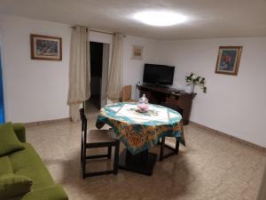 a living room with a table and a television at SEGESTA - Le Bouquet in Salemi