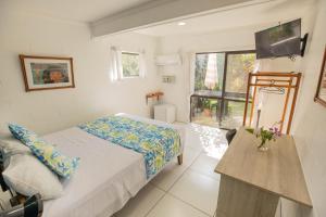 Habitación pequeña con cama y ventana en The Samoan Outrigger Hotel en Apia