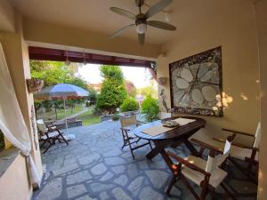 a dining room with a table and chairs and a patio at Georgia's house in Nikiti