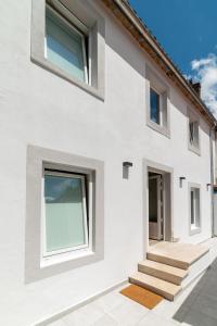 a white house with stairs and windows at Ultreia Seven Rooms by Adeloló in Santiago de Compostela