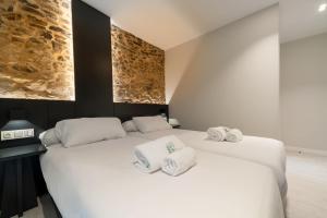 1 dormitorio con 2 camas y toallas. en Ultreia Seven Rooms by Adeloló, en Santiago de Compostela
