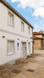 a white building with a door on the side of it at Ultreia Seven Rooms by Adeloló in Santiago de Compostela