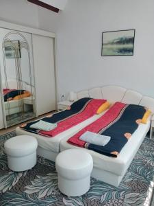 a bedroom with two beds and two stools at ROMANOWKA in Reda