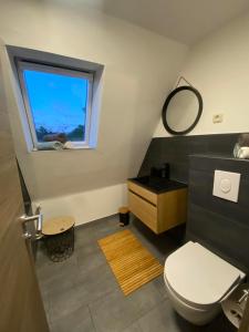 a bathroom with a toilet and a sink and a window at Ferienhaus International in Bad Harzburg +38 photos
