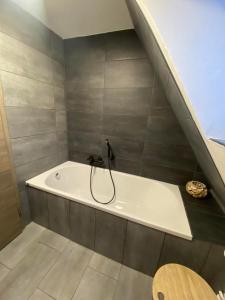 a bathroom with a bath tub in the corner of a room at Ferienhaus International in Bad Harzburg