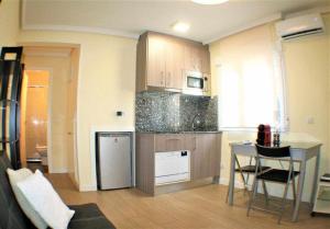 a kitchen with wooden cabinets and a table in a room at Apartamento cercano a Madrid Rio céntrico Nuevo in Madrid +24 photos