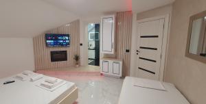 a white bathroom with two sinks and a fireplace at Pansion Eden in Niš