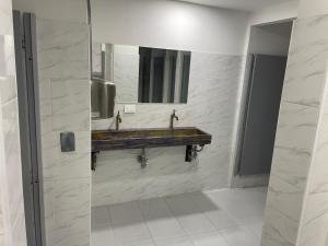 a bathroom with two sinks and a mirror at Hostal Casa Astromelia in Bogotá