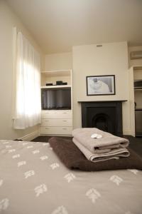 a bedroom with a bed with a fireplace and a television at Allawah Bendigo in Bendigo