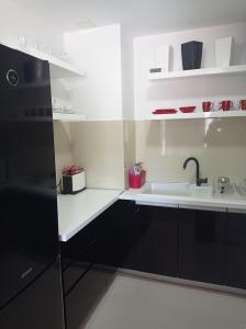 a kitchen with black cabinets and a sink at Red Lux in Budva