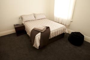 Schlafzimmer mit einem Bett und einem Fenster in der Unterkunft Allawah Bendigo in Bendigo