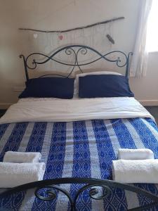 a bed with blue and white sheets and blue pillows at Fabulous location with sea and castle view - NC500 in Keiss