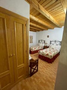 una habitación con dos camas en una habitación en La Serrota Casa Rural, en Navacepedilla de Corneja