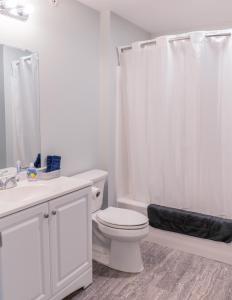 a white bathroom with a toilet and a shower at Allen Lake Resort Richfield Springs Cooperstown in Richfield Springs