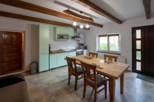 a kitchen with a wooden table and chairs at Casa Rustik Danes in Daneş