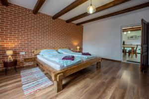 uma cama num quarto com uma parede de tijolos em Casa Rustik Danes em Danes