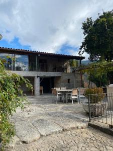 ein Haus mit einer Terrasse mit einem Tisch und Stühlen in der Unterkunft Quinta dos Mouras B&B in Rebordões