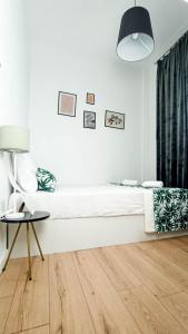 - une chambre blanche avec un lit et une table dans l'établissement DOWN TOWN Luxurious Apartments (4), à Alexandroúpolis