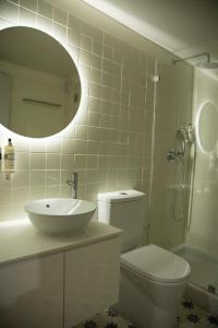 a bathroom with a sink and a toilet and a mirror at TOP Porto in Porto