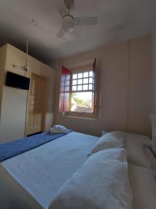 - une chambre avec un grand lit et une fenêtre dans l'établissement Pousada Casa Da Lapa, à Parati