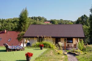 una casa con jardín y un banco en el patio en Przytulny Domek z Banią en Brzozowa