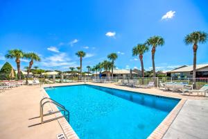 a swimming pool at a resort with palm trees at Cozy Sebring Condo with Screened Porch and Grill! in Sebring
