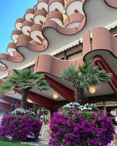 un edificio con palme e fiori di fronte ad esso di Hotel Flamingo a Gatteo a Mare