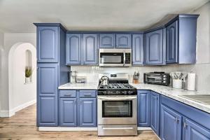 a blue kitchen with a stove and microwave at Orchard Park Home Less Than 2 Mi to Highmark Stadium! in Orchard Park