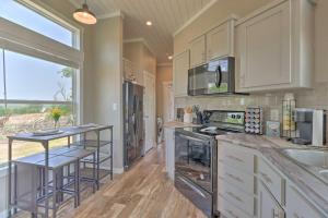 eine Küche mit weißen Schränken und einem großen Fenster in der Unterkunft Dog-Friendly Sunset Cabin with Wood Fire Pit! 
