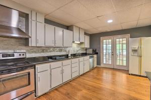 a large kitchen with white cabinets and stainless steel appliances at The B Haus Lakefront Retreat with Boat Ramp! in Pell City