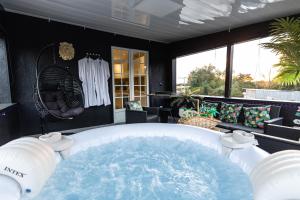 a hot tub in the middle of a room at Dynasty Home Spa Appartement 100M Jacuzzi Terasse in Holtzheim