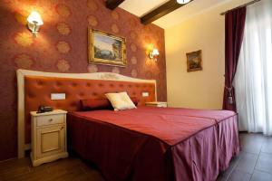 una camera con un letto con copriletto rosso di Hotel Villa Clementina a Scafati