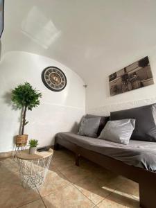 ein Wohnzimmer mit einer Couch und einer Uhr an der Wand in der Unterkunft Évora Romana Alojamentos T2 Aqueduto in Évora