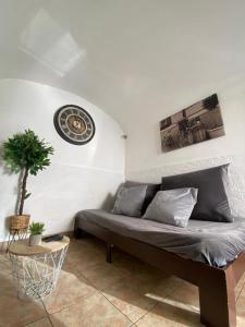 ein Wohnzimmer mit einer Couch und einer Uhr an der Wand in der Unterkunft Évora Romana Alojamentos T2 Aqueduto in Évora