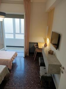 Pokój z 2 łóżkami, biurkiem i telewizorem w obiekcie Casa di Noemi - Seafront with parking w mieście Savona +30 zdjęć