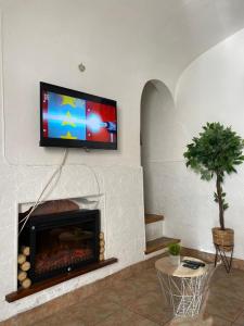 ein Wohnzimmer mit Kamin und TV darüber in der Unterkunft Évora Romana Alojamentos T2 Aqueduto in Évora