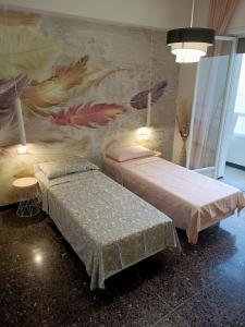 a room with two beds and a mural on the wall at La Casa di Noemi in Savona