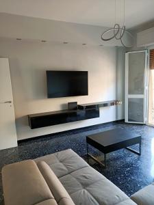 uma sala de estar com um sofá e uma televisão de ecrã plano em La Casa di Noemi em Savona